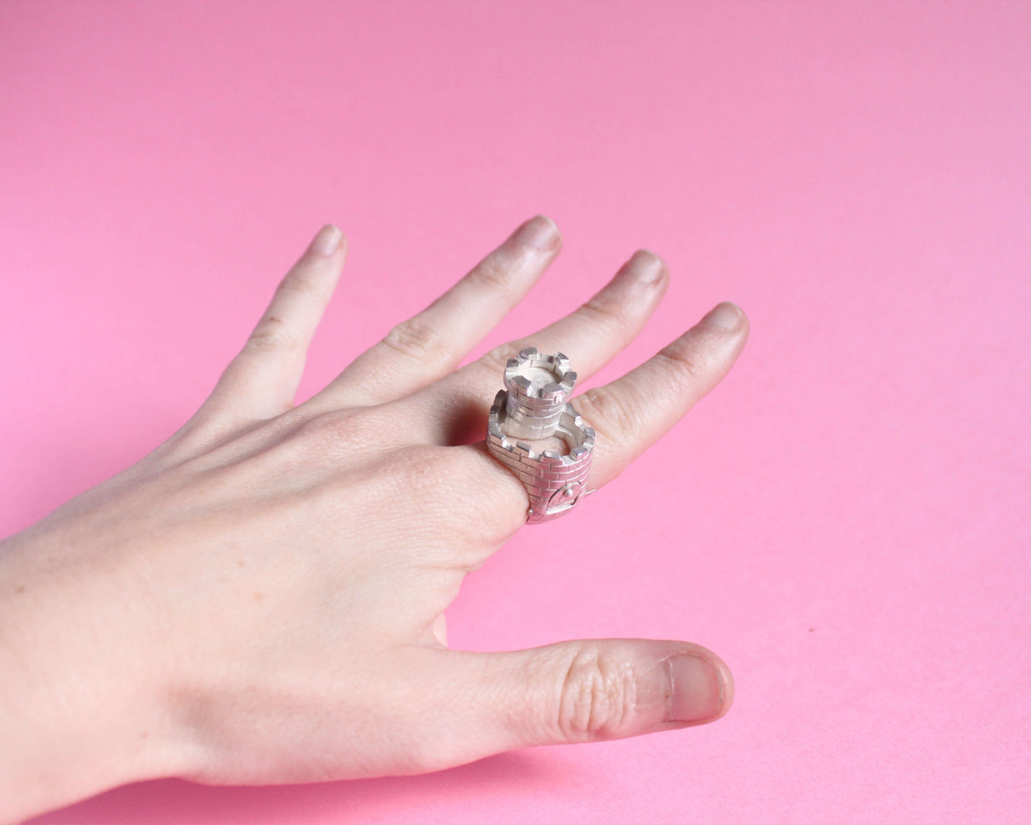 vue en angle d'une bague en argent en forme de château fort avec une tour