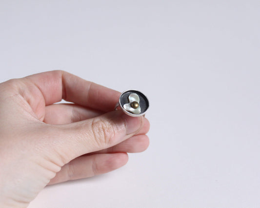 bague en argent en forme d'oeuf au plat dans une poêle