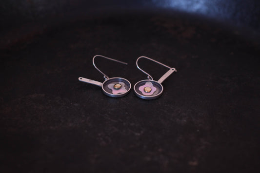 vue détaillée d'une paire de boucles d'oreilles en forme d'oeufs au plat en argent massif, en nacre et en laiton