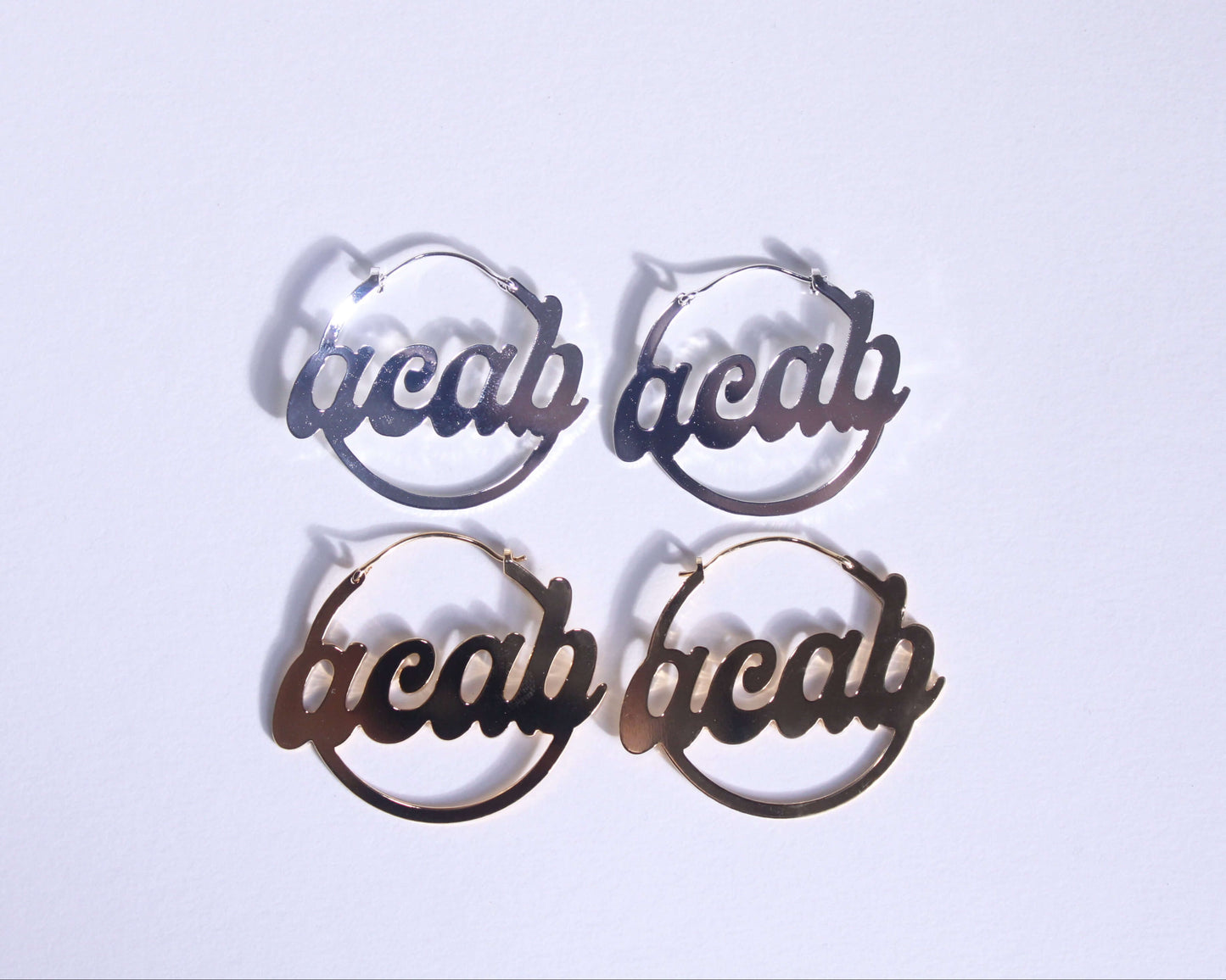 paires de créoles en laiton doré et en laiton plaqué argent portant la mention "ACAB"