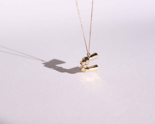 pendentif en laiton plaqué or symbolisant une paire de jumelles, suspendu au bout d'une chaine