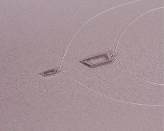 vue de coté de deux pendentifs en argent en forme de rectangles impossibles