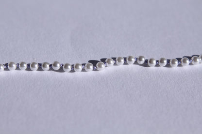 Zoom sur les perles et les noeuds de soie lila entre chaque perles