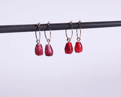 des boucles d'oreilles en laiton en forme d'arilles de grenade