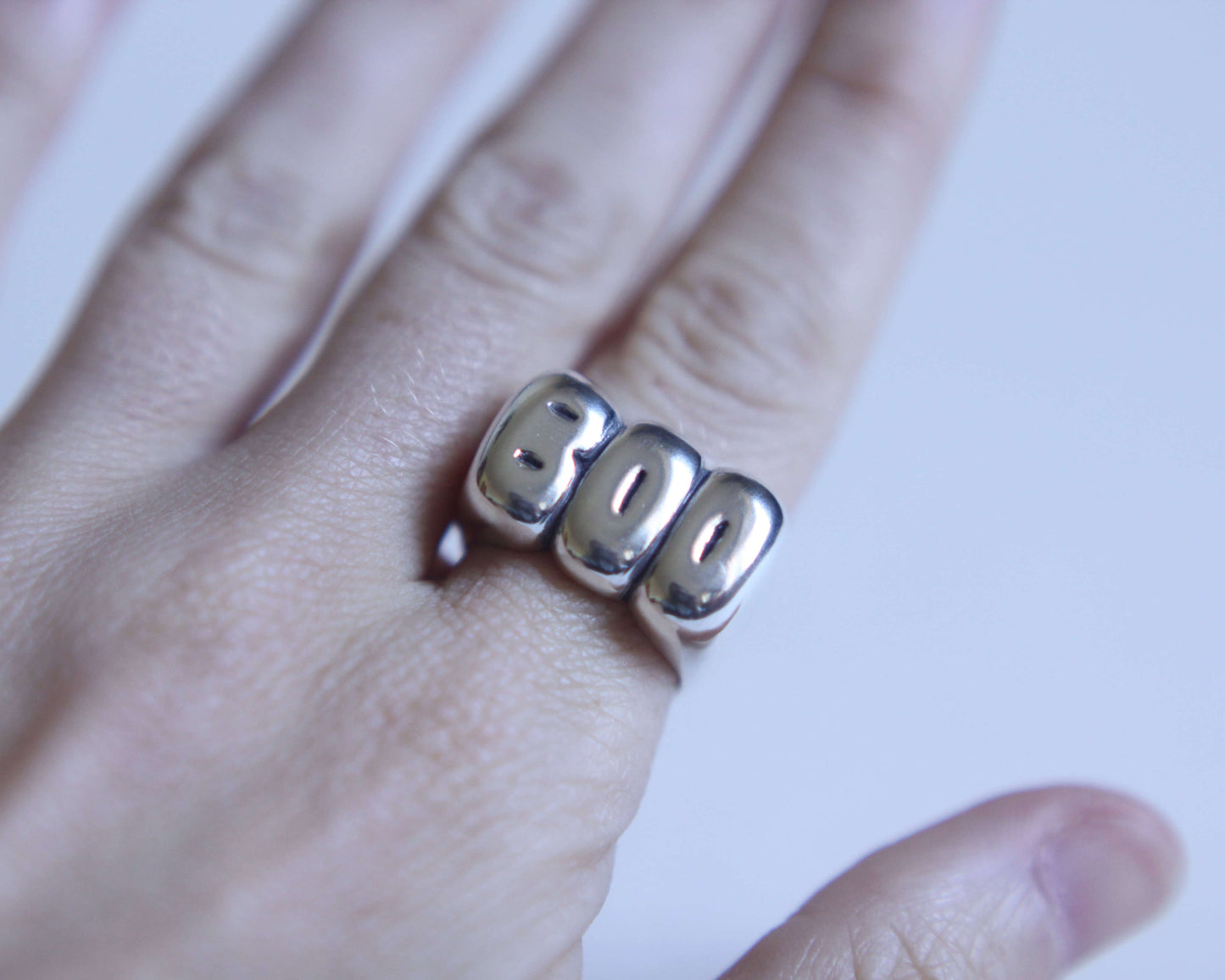 bague en argent massif représentant l'inscription "BOO" portée au doigt