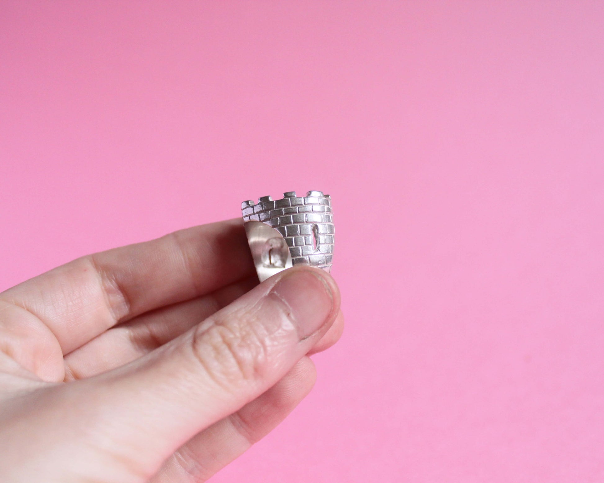 zoom sur la meurtrière d'une bague en argent massif représentant un château fort