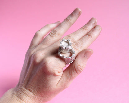 bague en argent massif symbolisant un château en forme de coeur avec une tour et un pont levis, portée au doigt