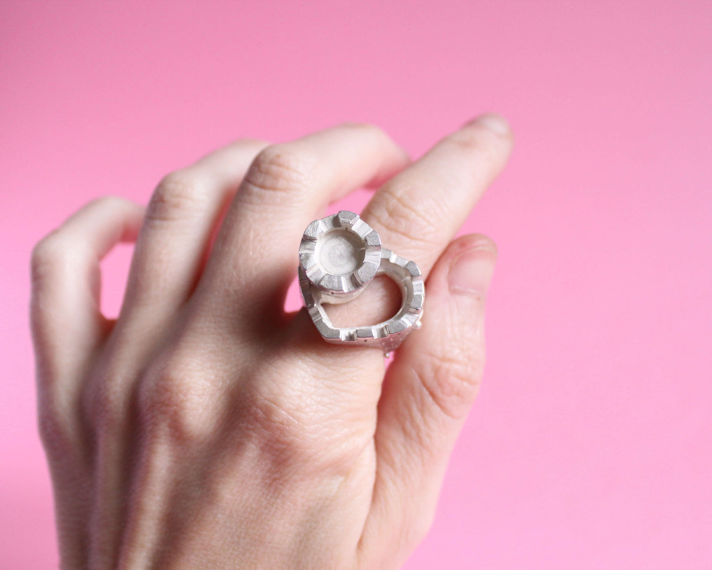 gros plan d'une bague représentant un château en forme de coeur avec une tour fortifiée