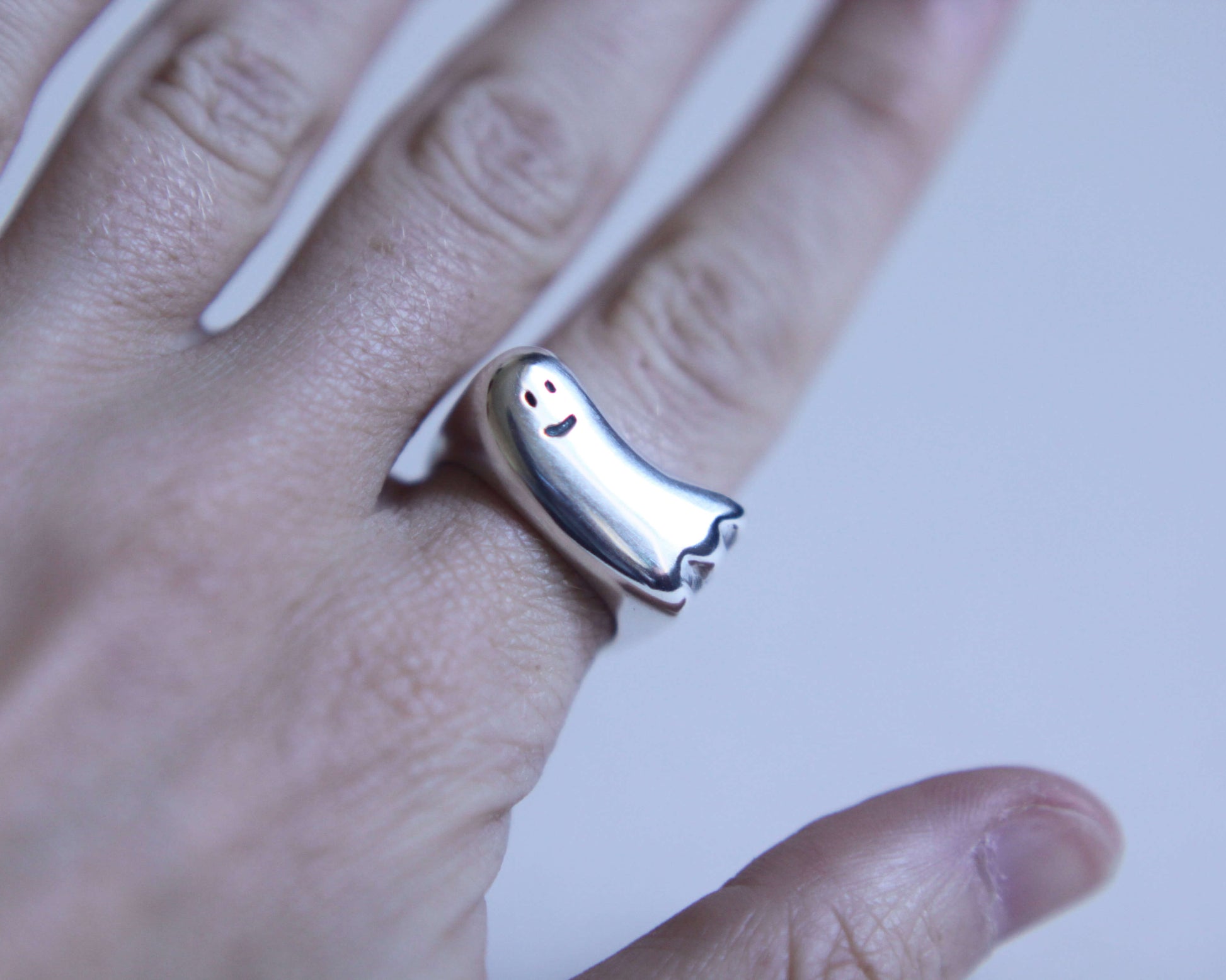 vue détaillée d'une bague en argent représentant un fantôme souriant