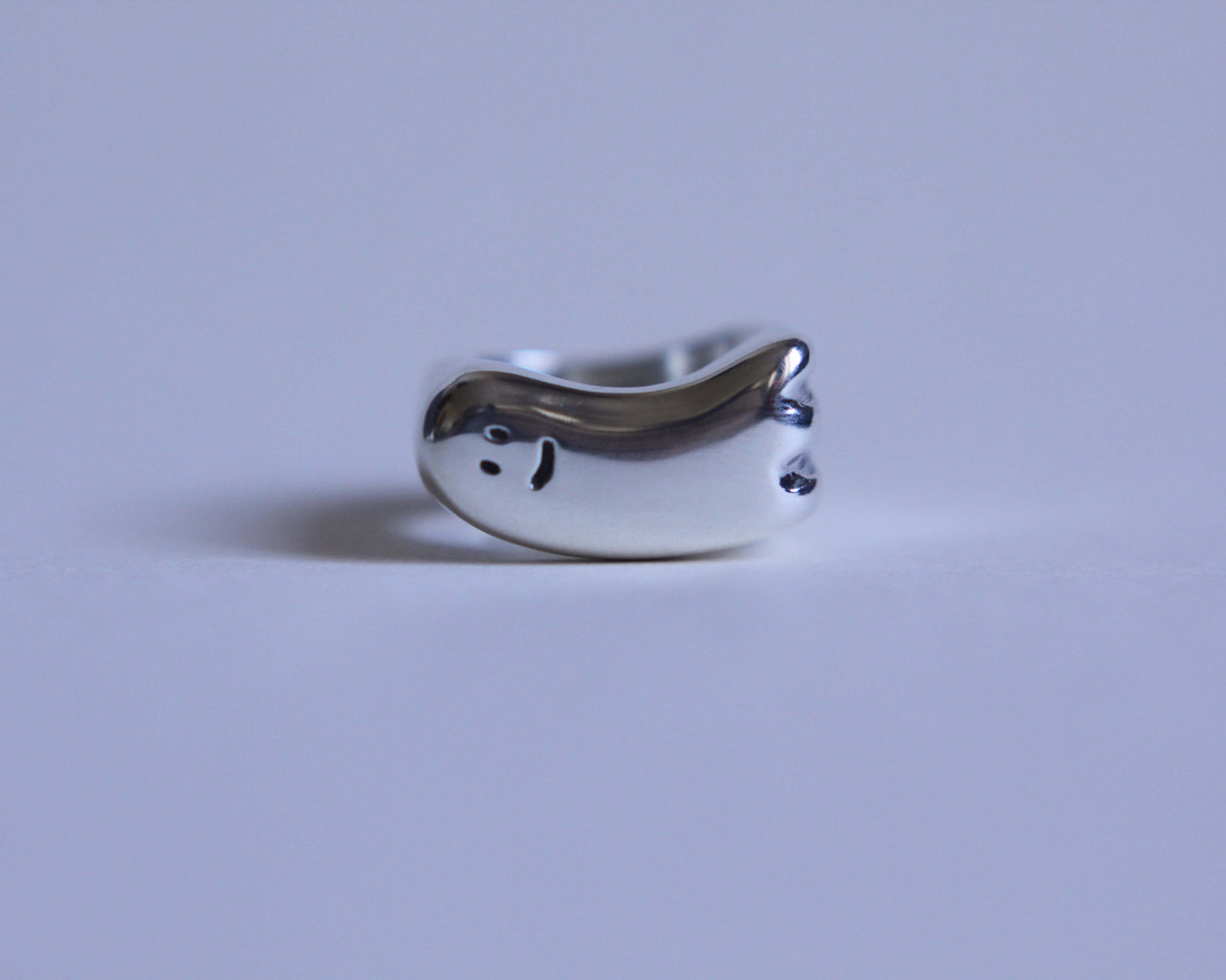 vue de face d'une bague en argent en forme de fantôme à l'air sympathique