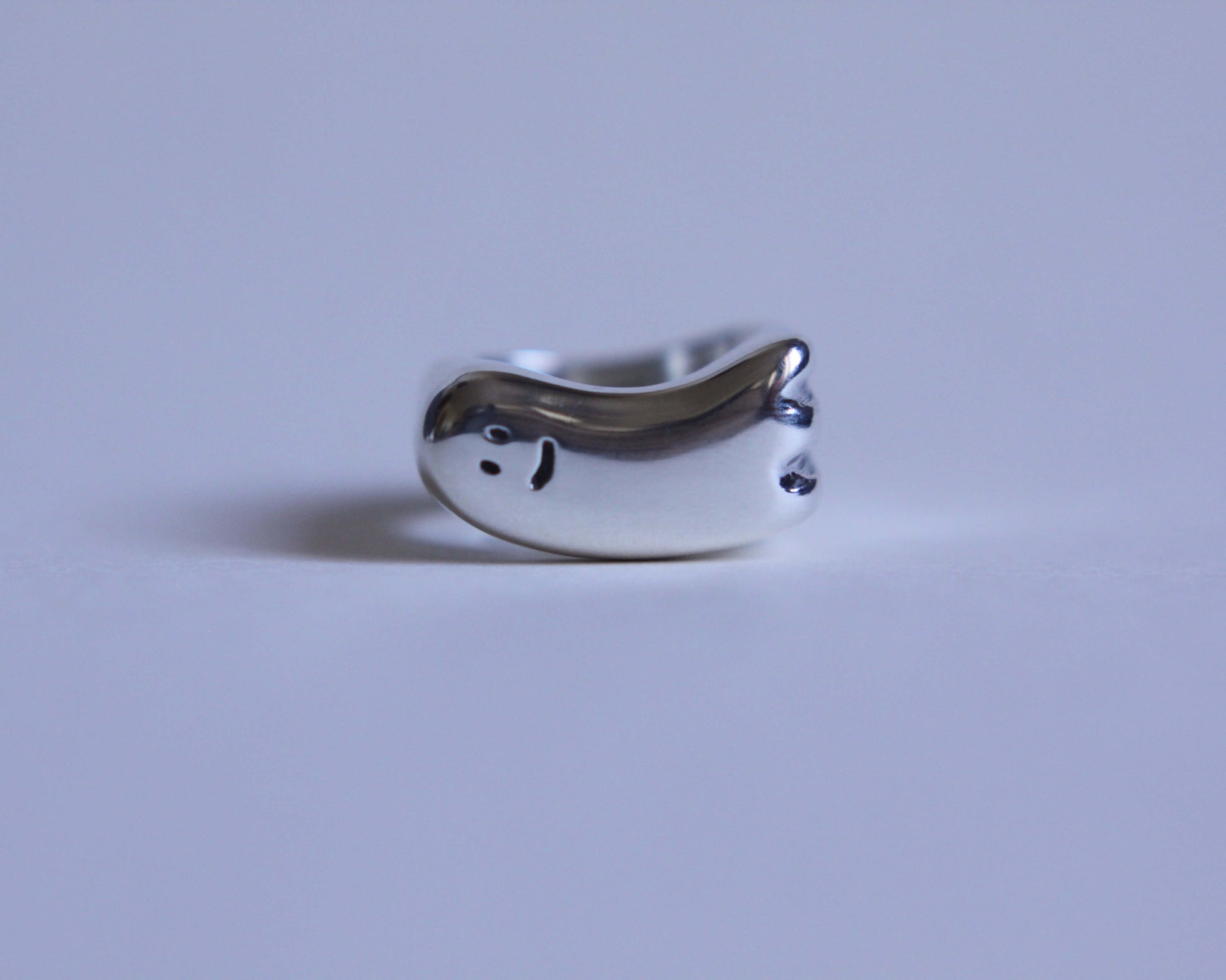 vue de face d'une bague en argent en forme de fantôme à l'air sympathique
