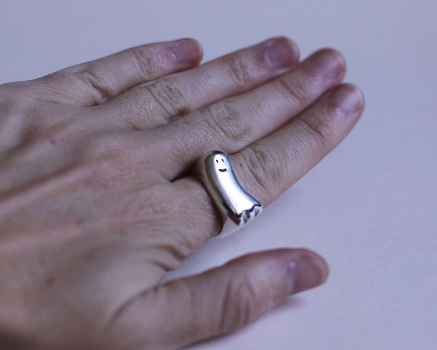 bague en argent massif représentant un fantôme qui sourit portée au doigt