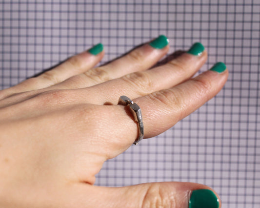 bague en forme de lunettes de piscine, portée au doigt