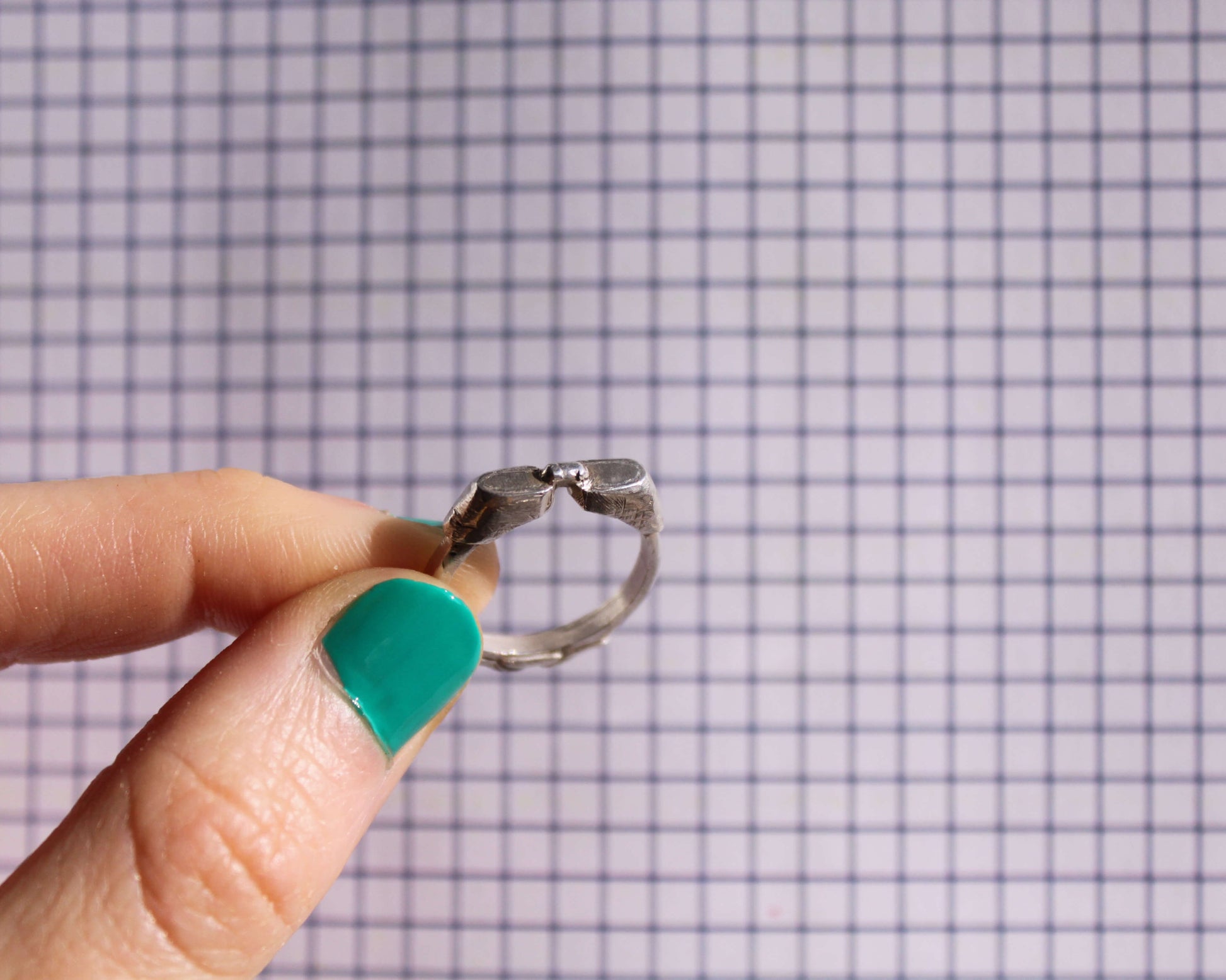 bague en argent massif en forme de lunettes de piscine tenue à la main