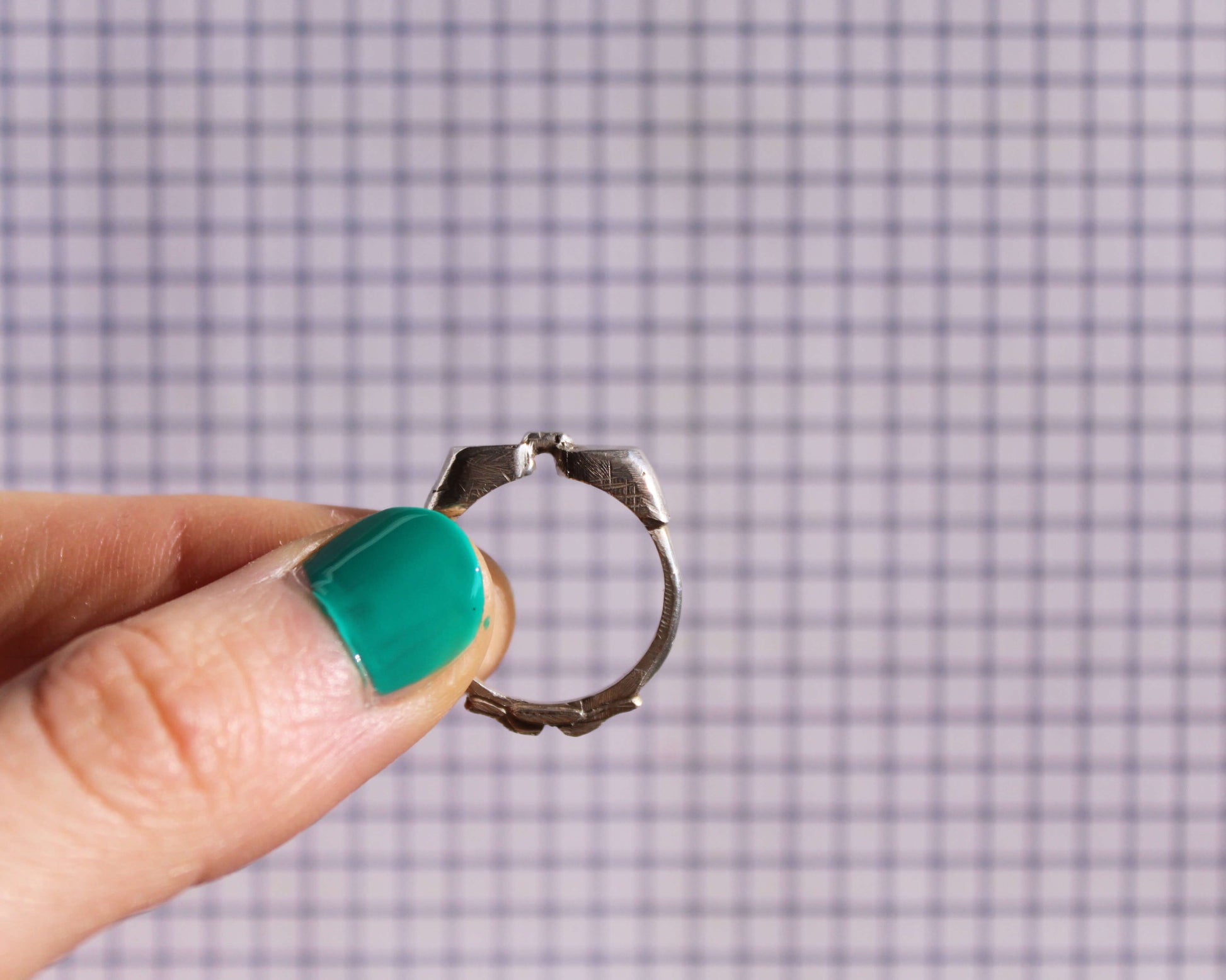 bague en argent massif représentant des lunettes de piscine, sur un fond à carreaux