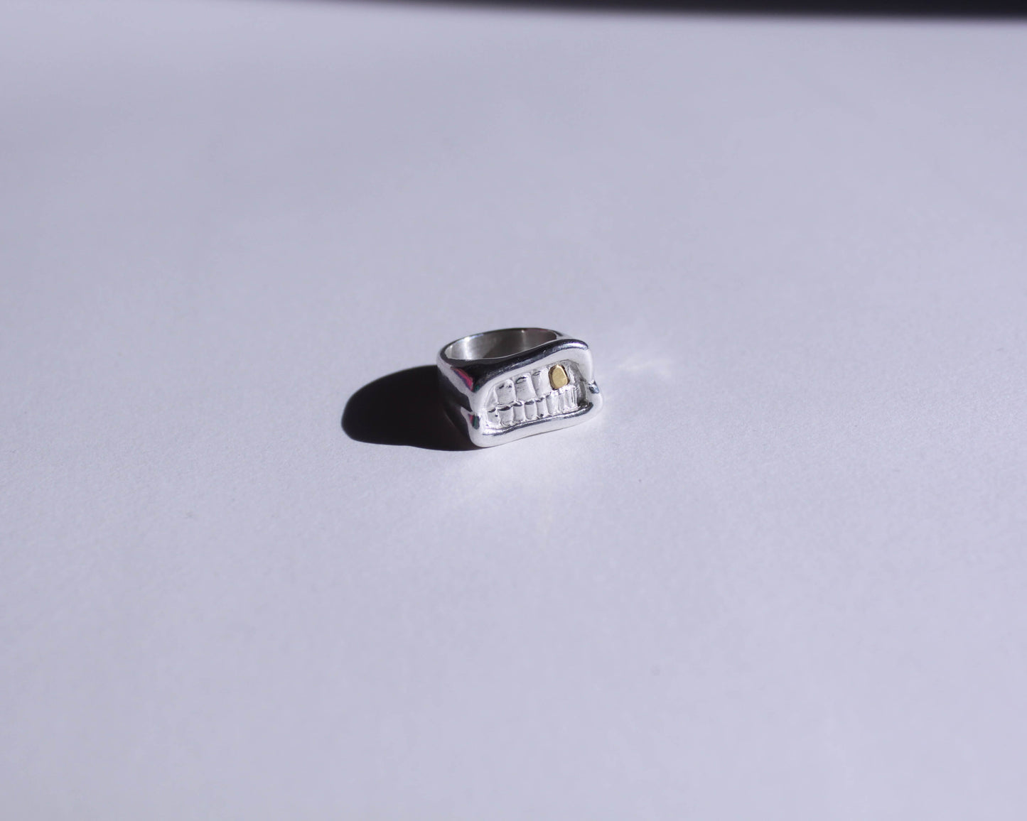 chevalière en argent massif en forme de bouche avec une dent en laiton