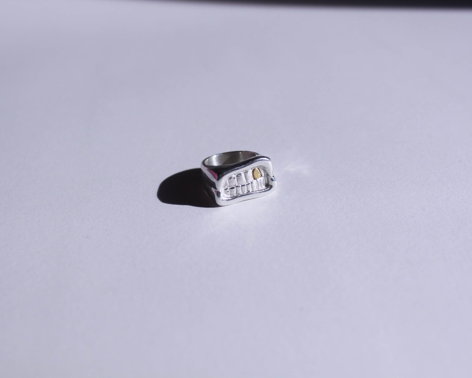 chevalière en argent massif en forme de bouche avec une dent en laiton