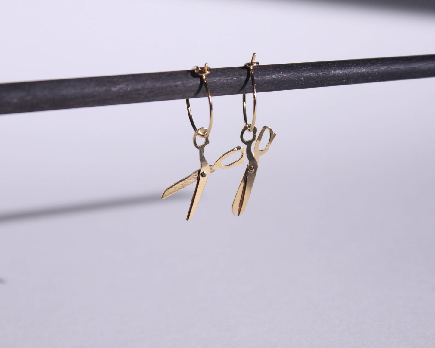 paire de boucles d'oreilles en laiton doré symbolisant des ciseaux