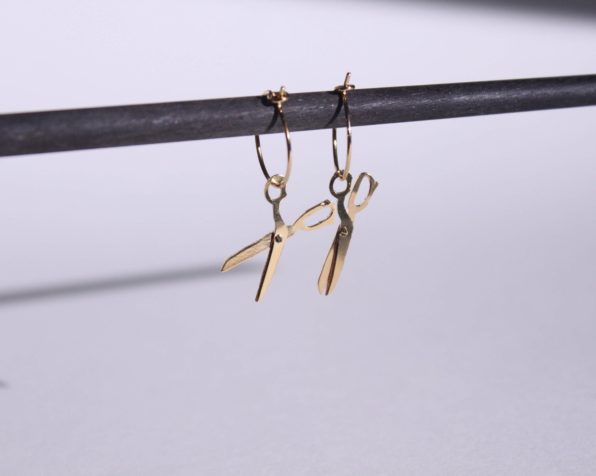 paire de boucles d'oreilles en laiton doré symbolisant des ciseaux