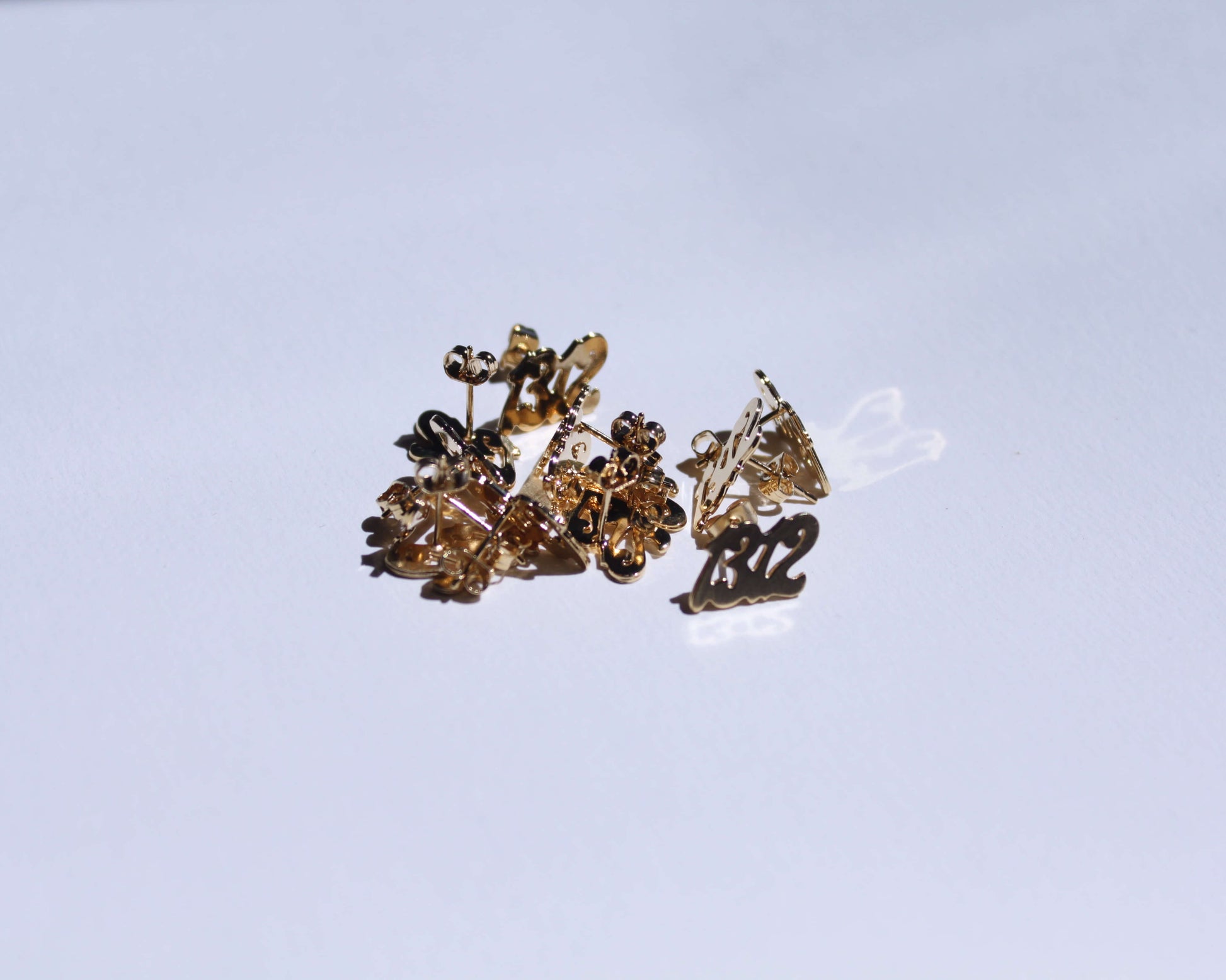 petit tas de boucles d'oreilles en laiton doré en forme de nombre "1312"