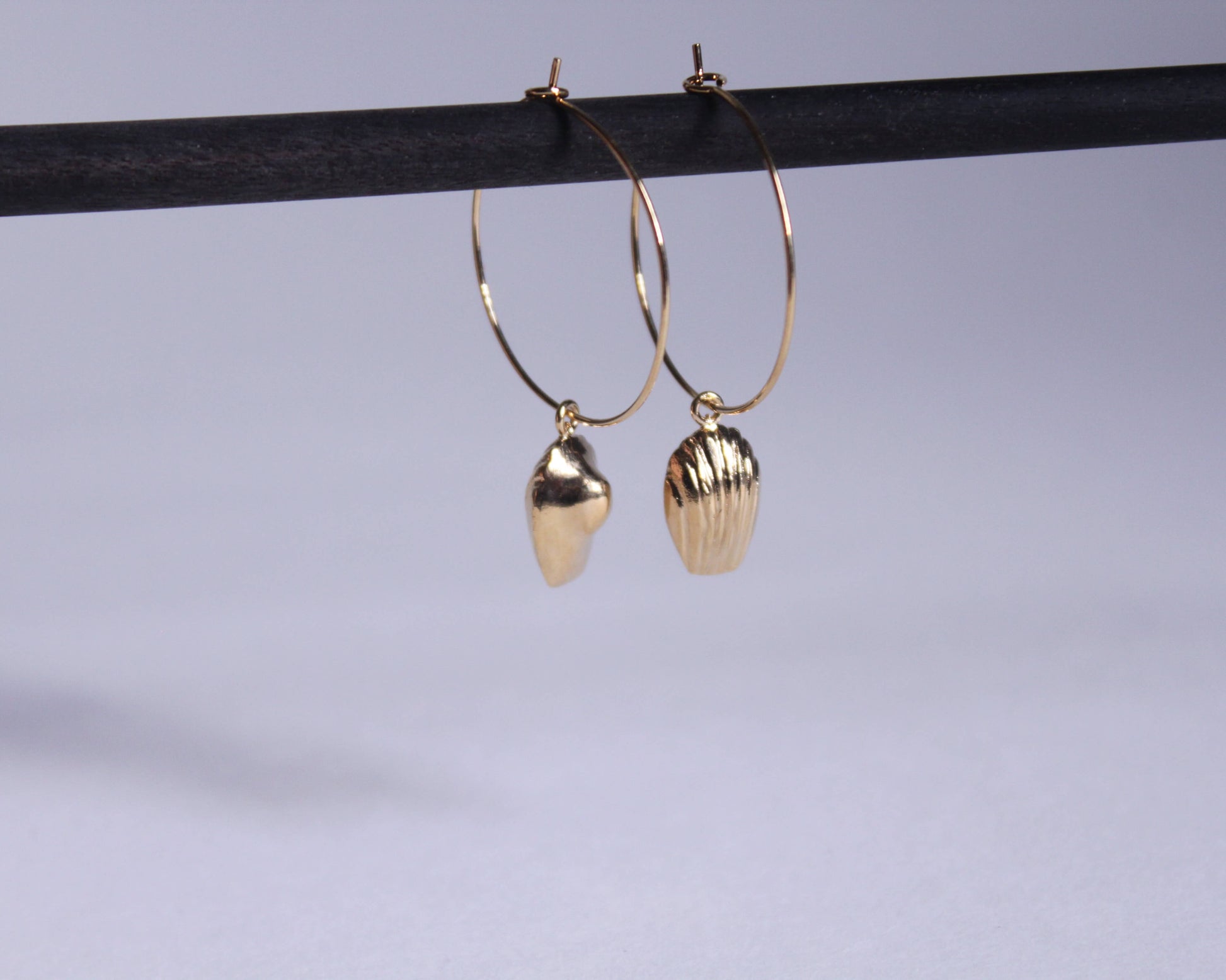 boucles d'oreilles en laiton plaqué or en forme de madeleine accroché à des anneaux