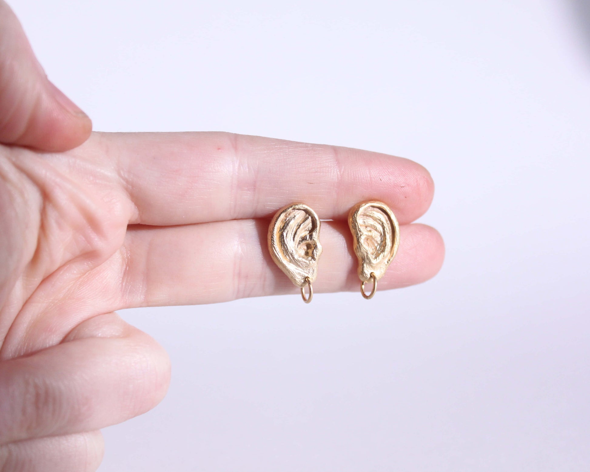 paire de boucles d'oreille en laiton plaqué or représentant des oreilles