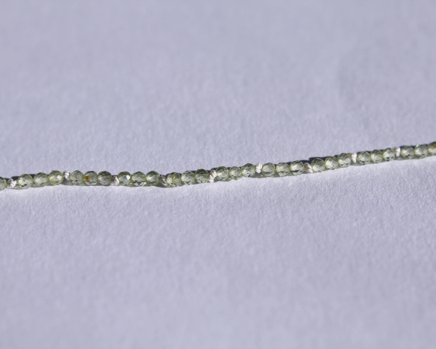 Zoom sur le collier en perles en peridot facetté