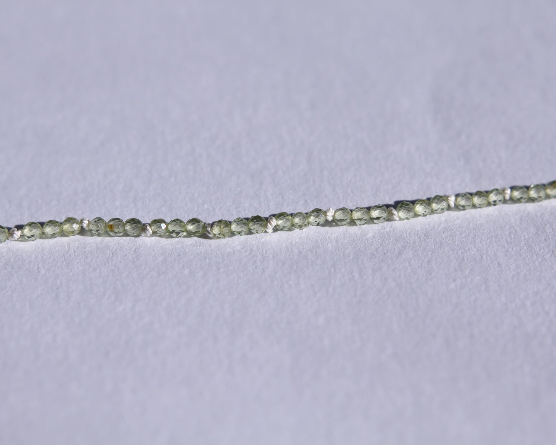 Zoom sur le collier en perles en peridot facetté