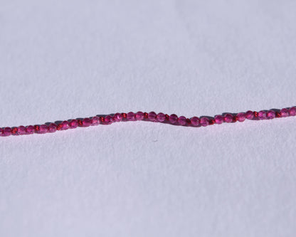 Zoom sur les perles en rubis facetté et les noeuds du fil de soie