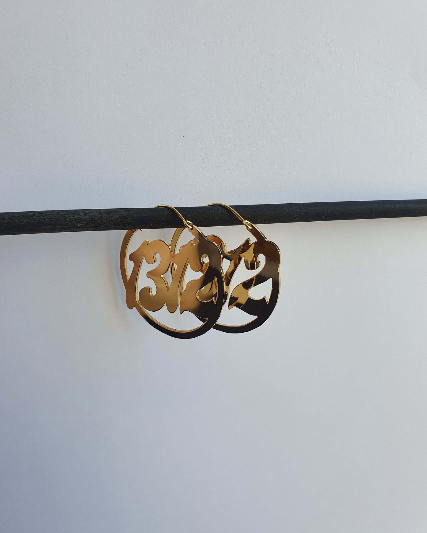 une paire de créoles en laiton doré représentant le nombre 1312