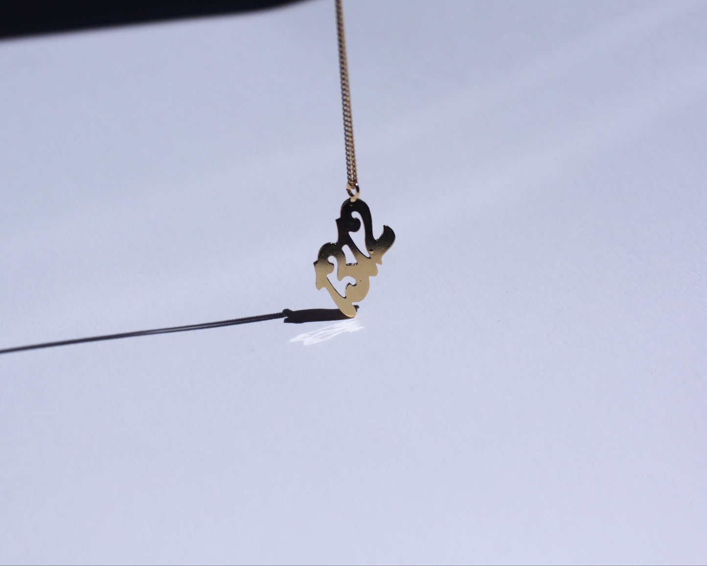 pendentif en laiton doré représentant le nombre "1312"