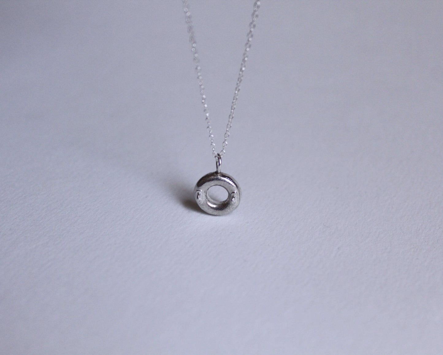 vue du dessus d'un pendentif en argent massif représentant une bouée