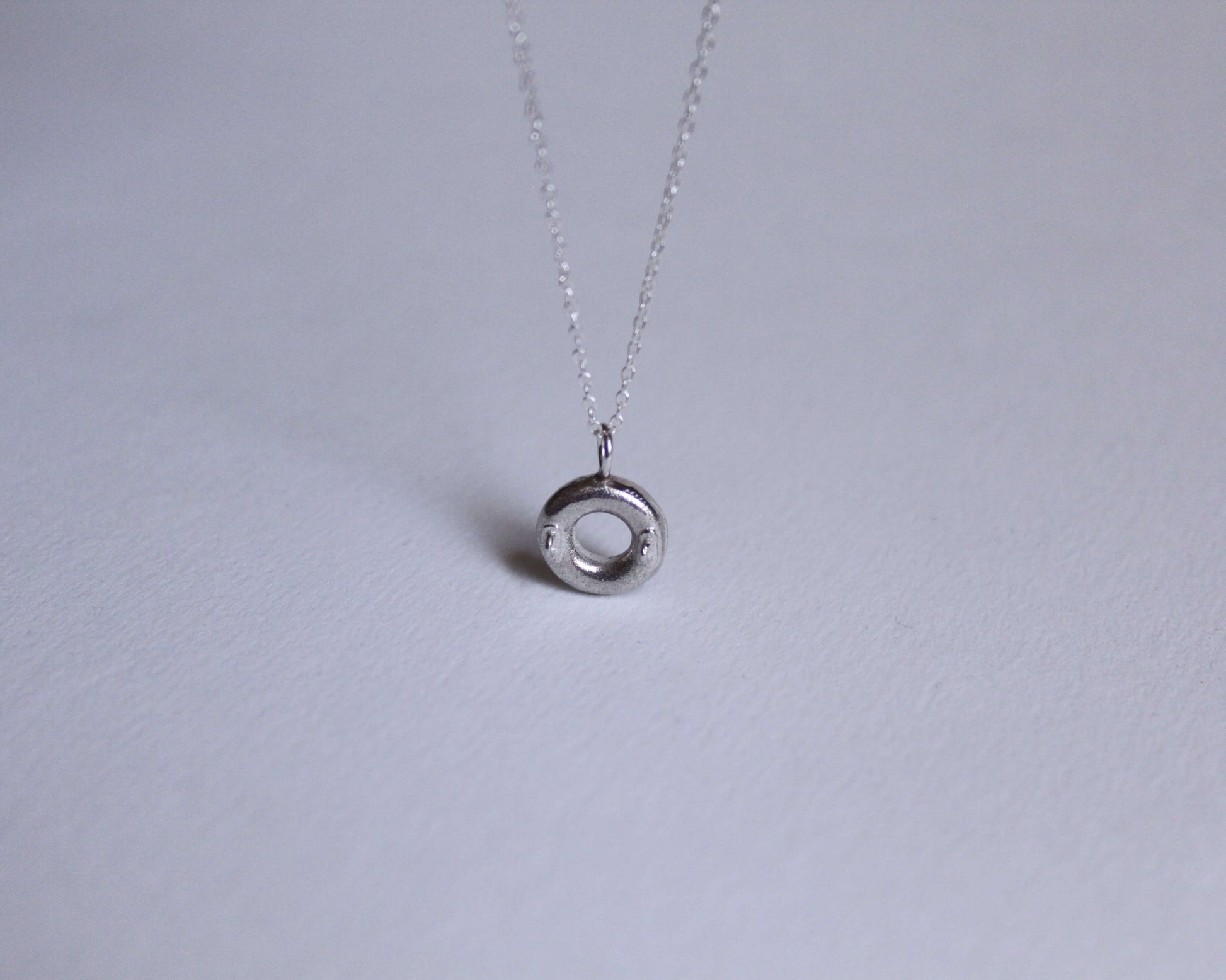 vue du dessus d'un pendentif en argent massif représentant une bouée