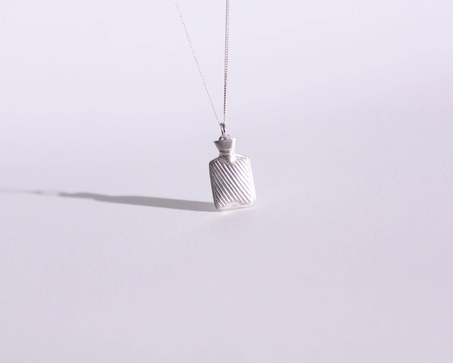 collier avec un pendentif en argent massif représentant une bouillotte