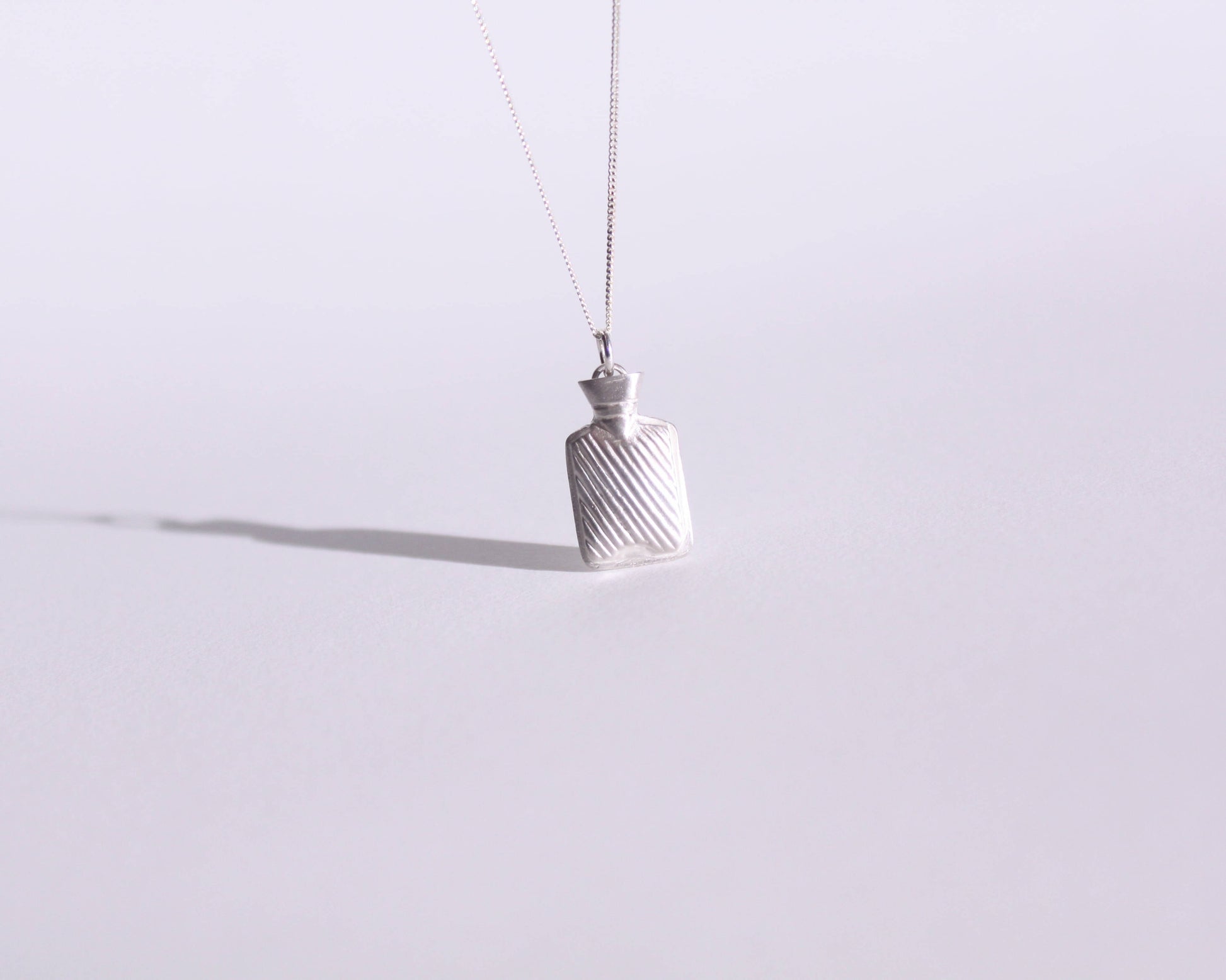 collier avec un pendentif en argent massif représentant une bouillotte