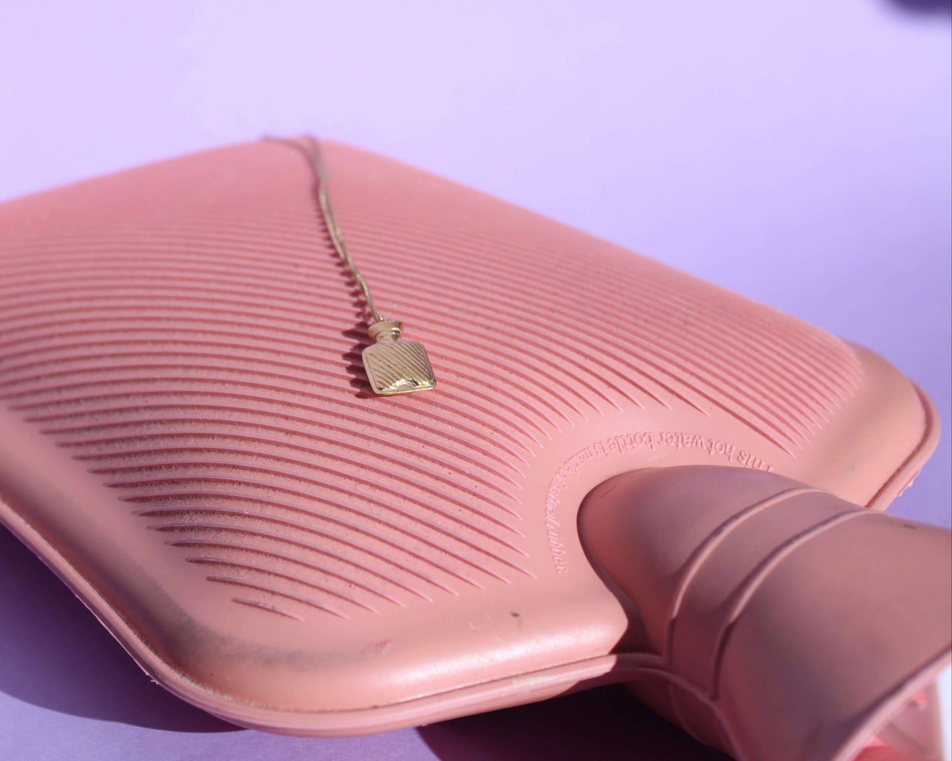 pendentif représentant une bouillotte en laiton plaqué or