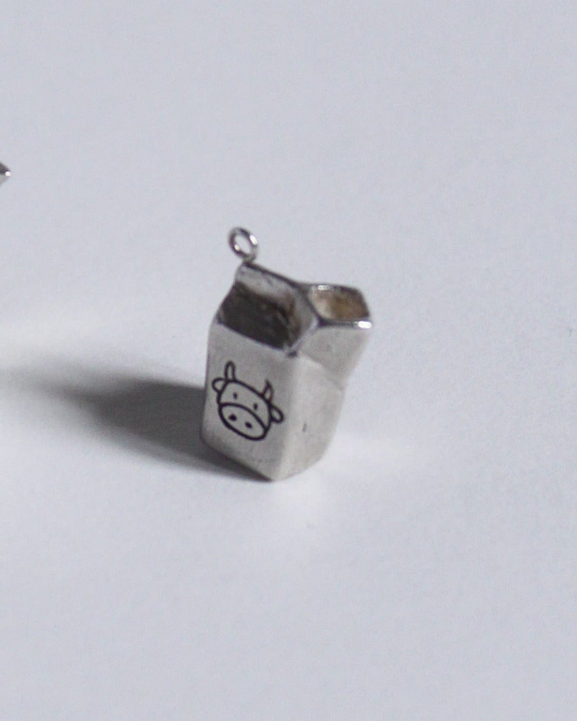 un pendentif en argent massif en forme de brique de lait de vache