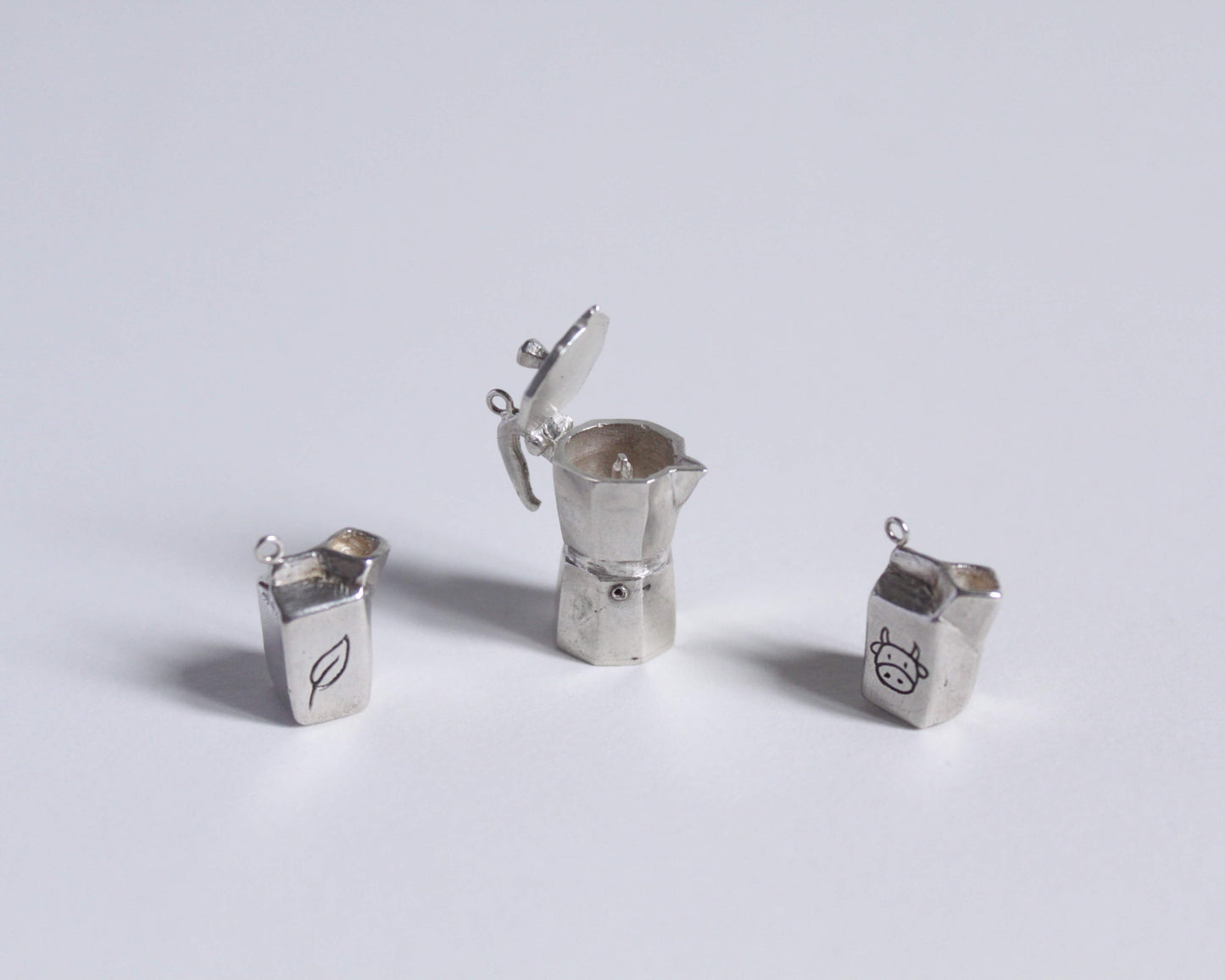 un pendentif en argent représentant une cafetière italienne ouverte