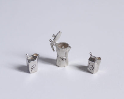 un pendentif en argent représentant une cafetière italienne ouverte