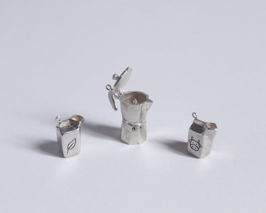 un pendentif en argent représentant une cafetière italienne ouverte