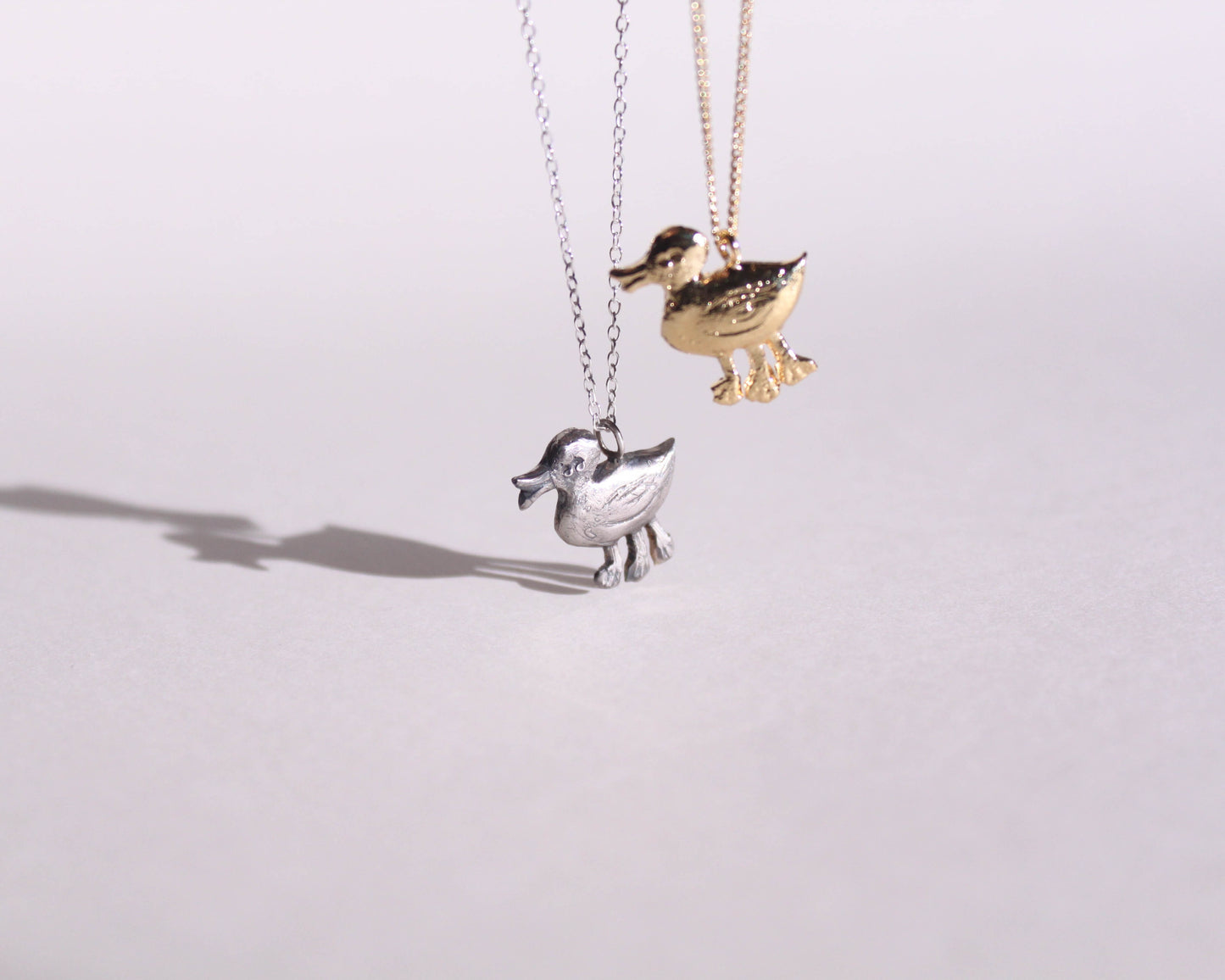 pendentifs en argent massif et en laiton plaqué or représentant des canards disposant de trois pattes