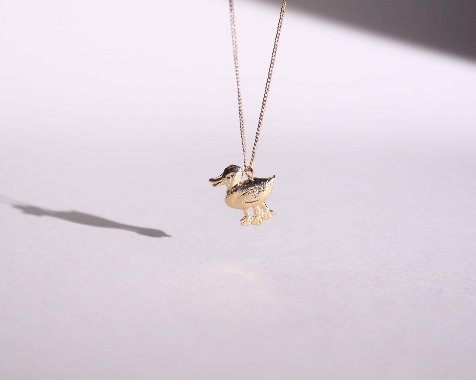 pendentif en laiton plaqué or symbolisant un canard disposant de trois pattes