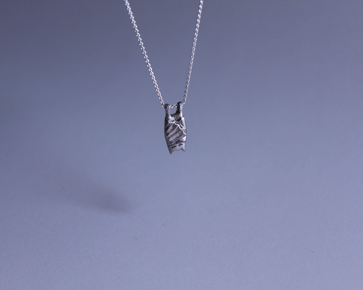 pendentif en argent symbolisant un chauve souris qui dort
