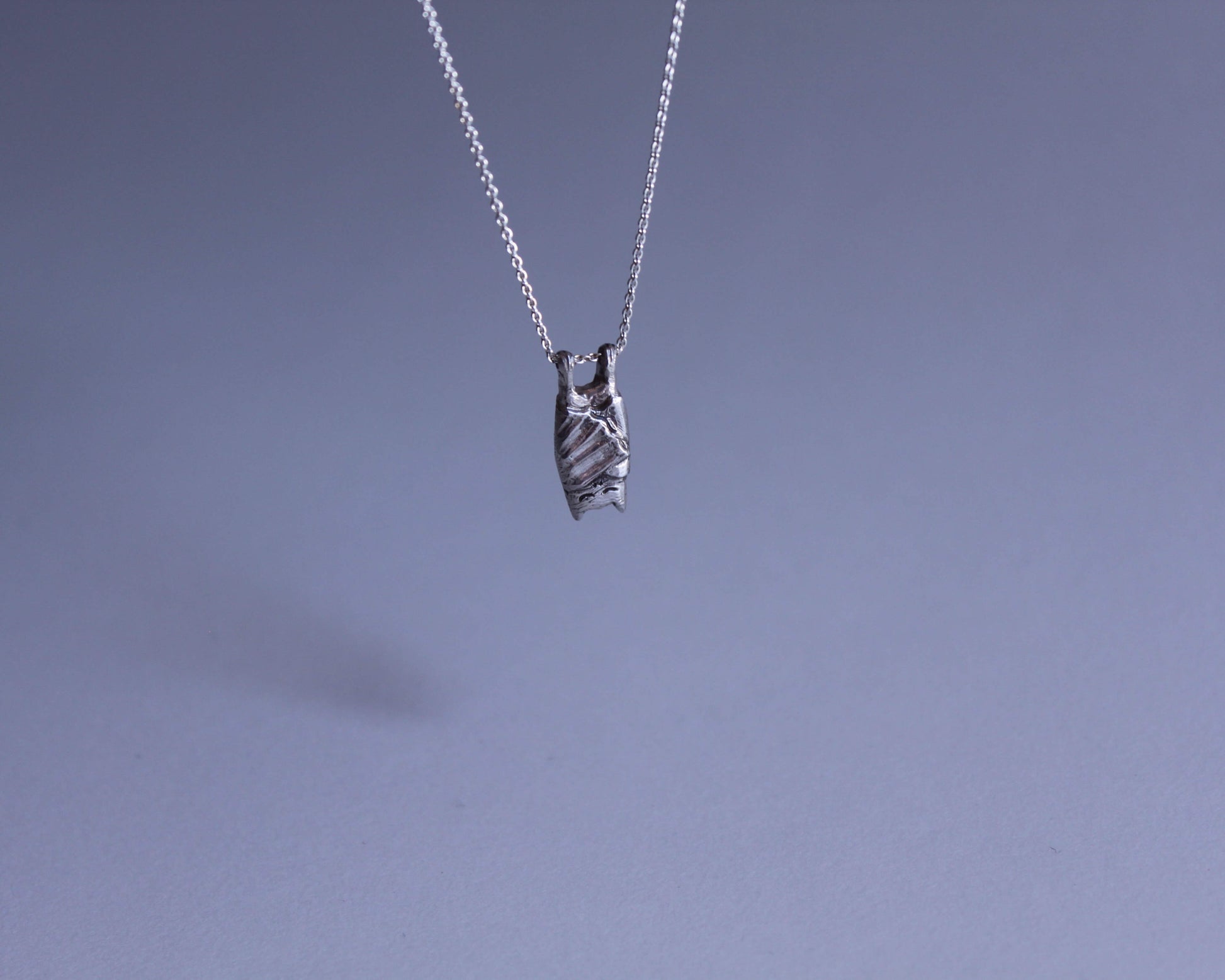 pendentif en argent symbolisant un chauve souris qui dort