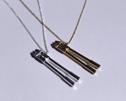 deux pendentifs en laiton plaqué or et en argent massif en forme de coupes boulons