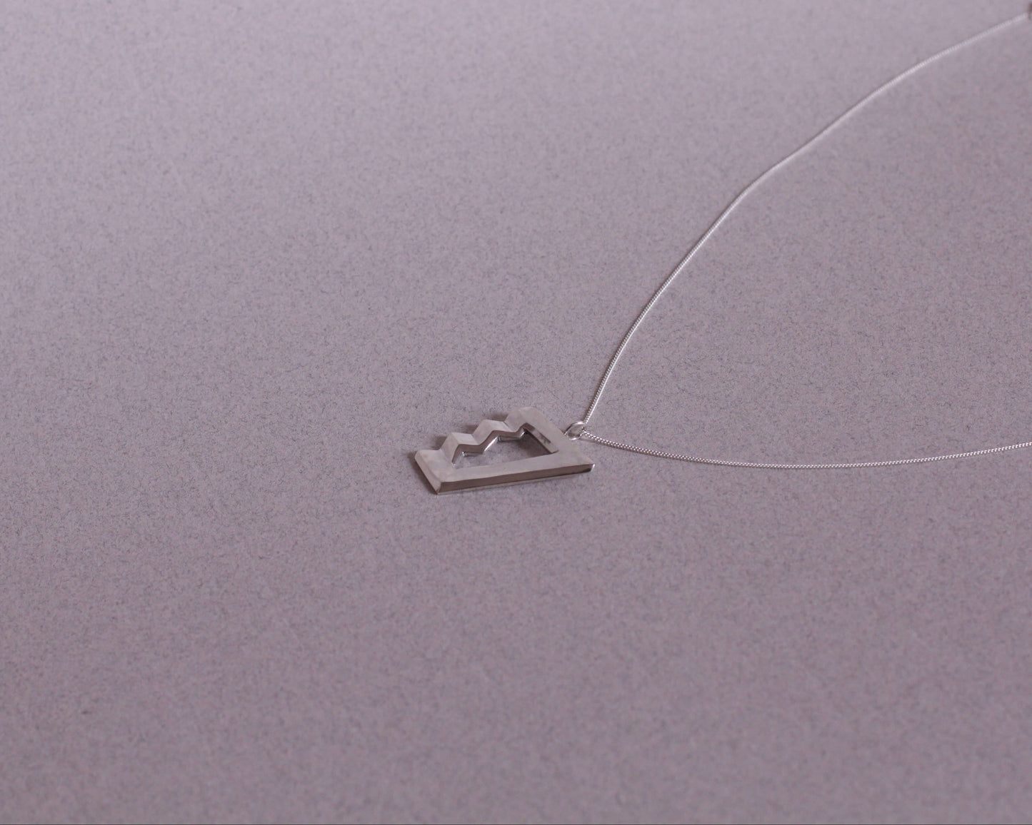 collier avec un pendentif en argent massif en forme d'escalier impossible