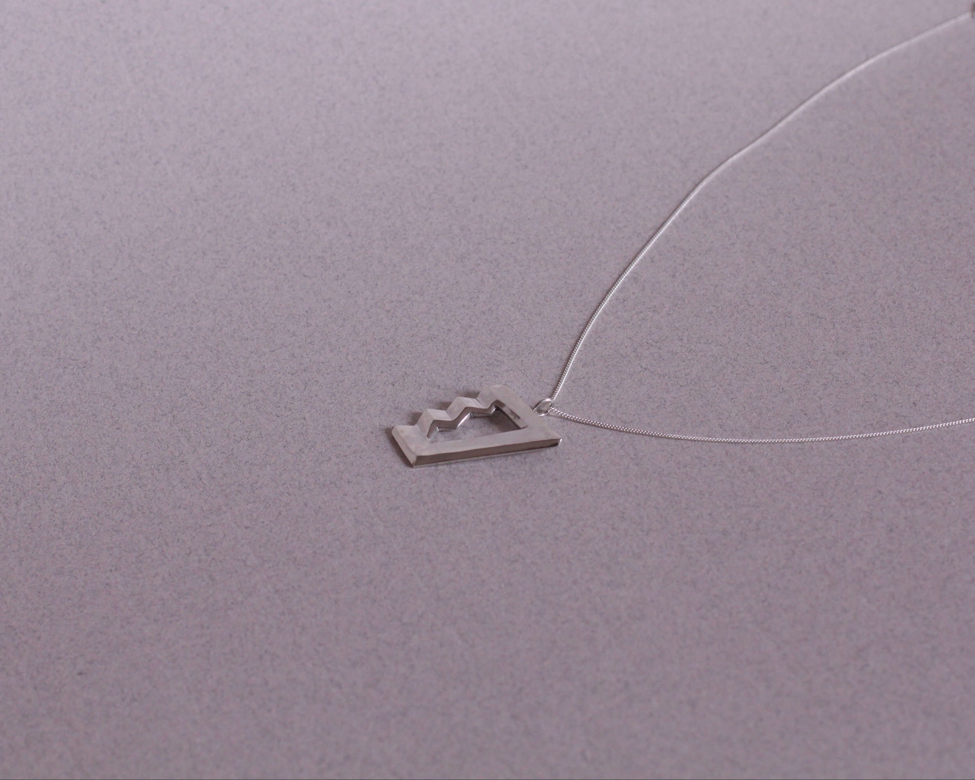 collier avec un pendentif en argent massif en forme d'escalier impossible