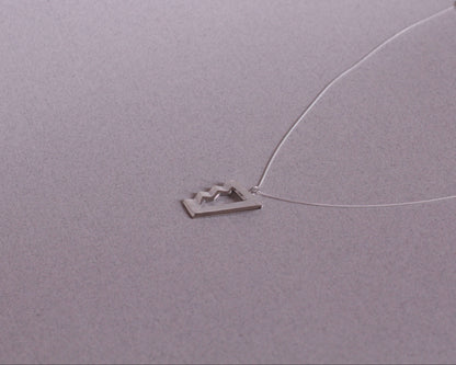 collier avec un pendentif en argent massif en forme d'escalier impossible