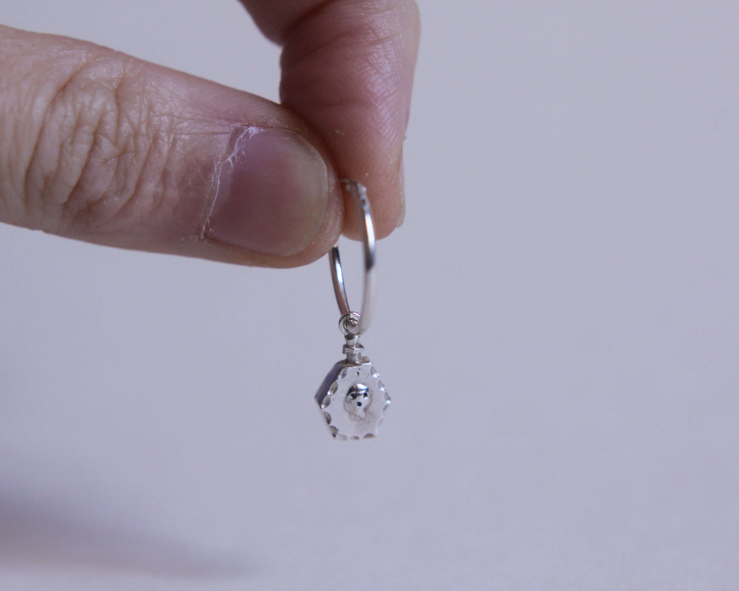 pendentif en forme de fiole poison avec un crâne accroché à un anneau en argent