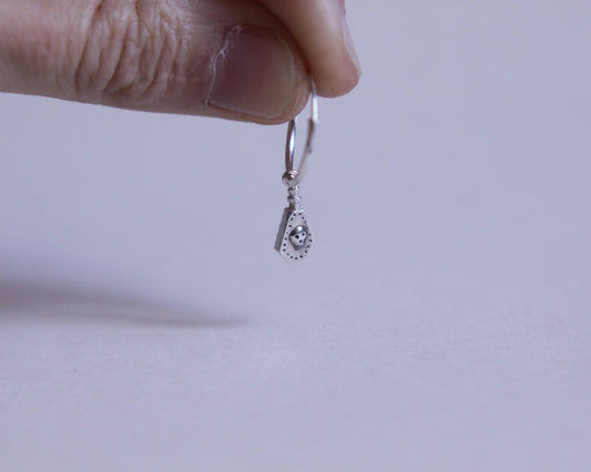 boucle d'oreille en argent massif représentant une fiole de poison avec un crâne dessus